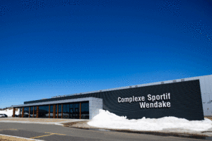 Black anodized curtain walls and commercial doors at the Wendake Arena